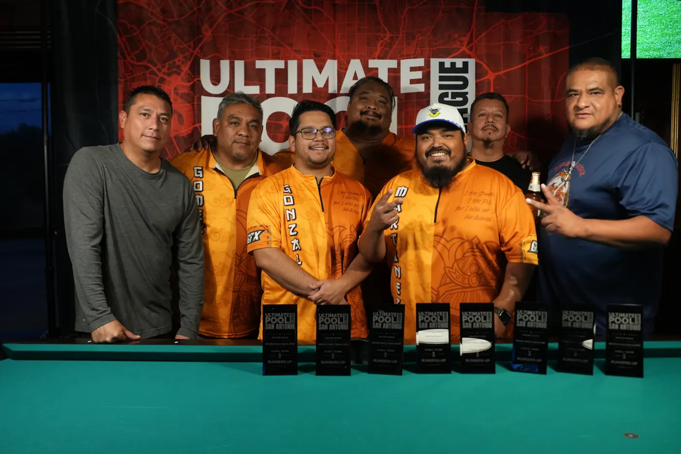 Drunken Masters in their orange jerseys behind a row of Runners-Up trophies at Fast Eddie's Braun.